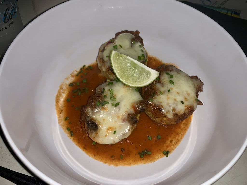 Gourmet stuffed appetizers topped with melted cheese, tomato sauce, chives, and a fresh lime wedge at Cabana Bar in Vero Beach, Florida