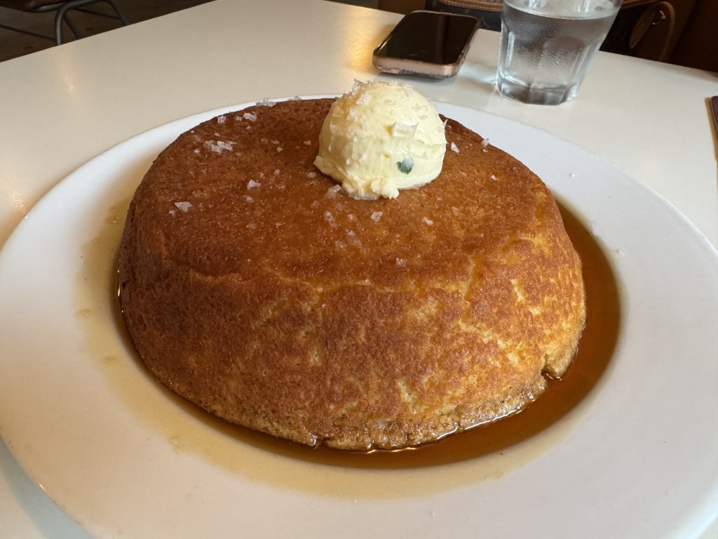 A thick, fluffy pancake topped with whipped butter and maple syrup at Chug's Diner in Miami, Florida