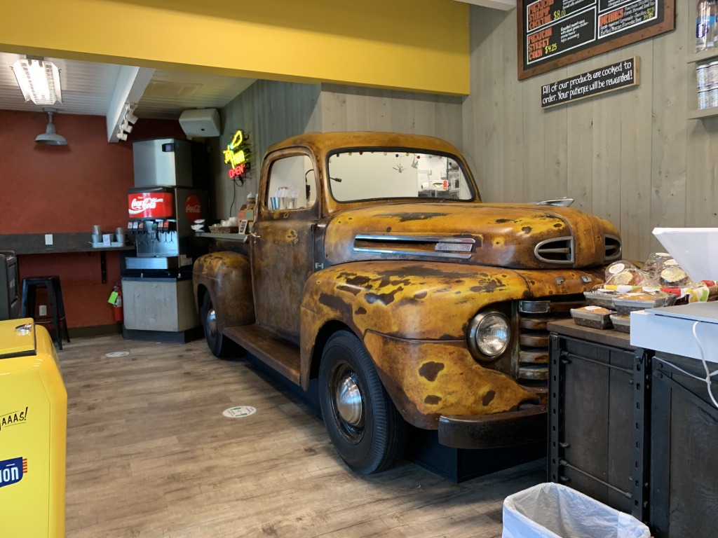 Rustic yellow Ford pickup truck turned service counter inside the colorful interior of El Sid Taqueria in Vero Beach, Florida