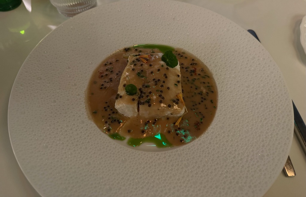Delicate poached steelhead trout served in a citrus emulsion on textured ceramic ware at Le Jardinier in the Miami Design District, Florida