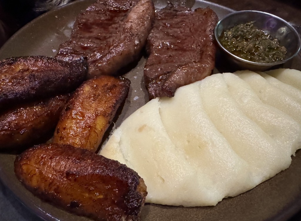 Prime Picanha en Vara cooked over wood fire served with sweet fried plantains, arepa mash, and chimichurri at Mordisco in Doral, Florida