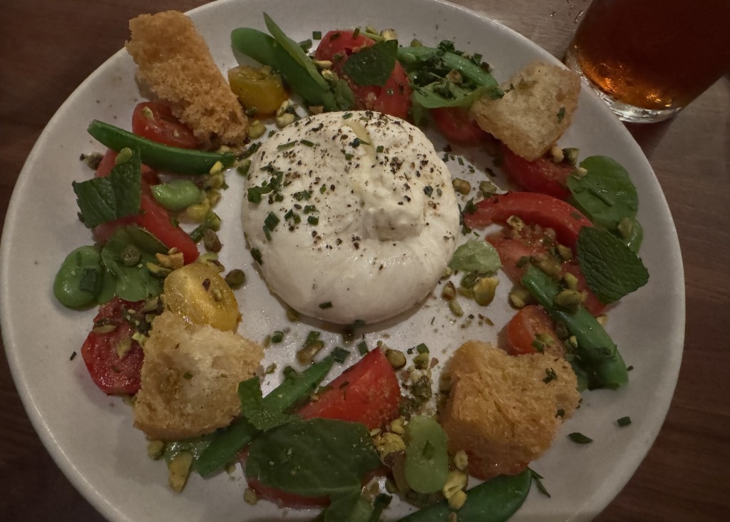 Fresh burrata salad with heirloom tomatoes, snap peas, grilled ciabatta croutons, and pistachios at North Italia in Aventura, Florida