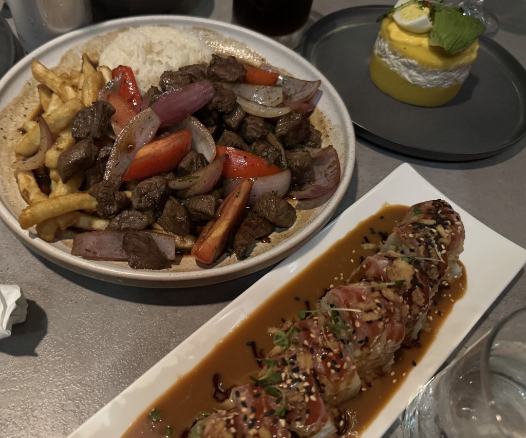 Traditional Peruvian lomo saltado steak stir-fry with french fries, causa de atun potato cake, and acevichado rolls at Tacu Taku Peruvian Kitchen in Pembroke Pines, Florida